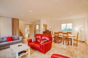 a living room with a red couch and a table at La Maison du Lac in Montceau-les-Mines