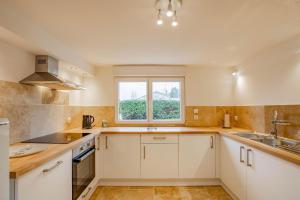 a kitchen with white cabinets and a window at La Maison du Lac in Montceau-les-Mines +15 photos