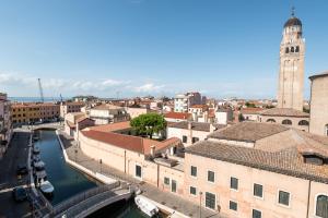 a view of a city with a canal and a clock tower at Alloggi Venca' in Chioggia