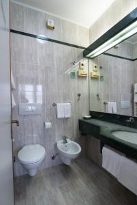 a bathroom with a sink and a toilet and a mirror at Alloggi Venca' in Chioggia