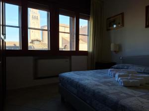 a bedroom with two beds and a large window at Alloggi Venca' in Chioggia +2 photos