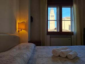 a bedroom with a bed with towels on it at Alloggi Venca' in Chioggia