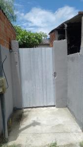 an open gate to a house with a white fence at Vila Bárbara térreo in Araruama
