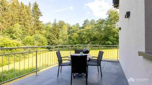 a patio with a table and chairs on a balcony at Mom's Home in Burg-Reuland
