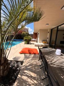 a patio with orange pillows and a swimming pool at Villa Bartolini in Bruges