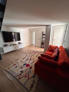 a living room with a couch and a flat screen tv at Villa Bartolini in Bruges