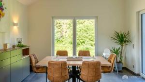 a dining room with a table and chairs and a window at Mom's Home in Burg-Reuland