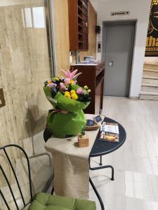 a vase of flowers on top of a table at Ulysses Apartments Ermou in Athens +3 photos