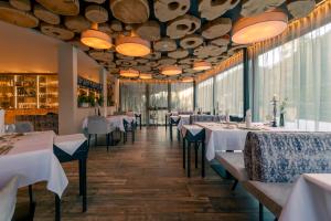 a dining room with white tables and chairs at FONTIS luxury spa lodge in Santa Maddalena in Casies Valbassa