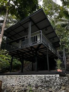 a house with a balcony on top of a stone wall at Ingphai Homestay in Suratthani