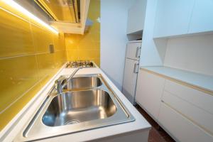 a stainless steel sink in a small kitchen at Condominio Dunelba in Marina di Campo +184 photos