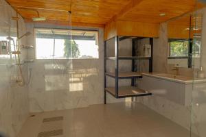 a bathroom with a shower and a sink and a mirror at Sunray Hill in Ranong
