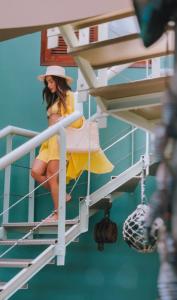a woman in a yellow dress and hat sitting on a boat at Acuario Pousada in Arraial do Cabo +44 photos
