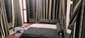 a bed in a room with two large windows at Ingphai Homestay in Suratthani