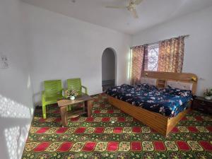 a bedroom with a bed and two green chairs at Payer Resort in Pharkian