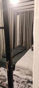 a bedroom with two beds and a window with curtains at Ingphai Homestay in Suratthani