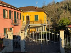 a yellow house with a gate in front of it at Cà Turi Sarzana in Sarzana +5 photos