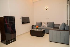 a living room with a couch and a tv at Trinco Beachfront Villas AJS in Trincomalee
