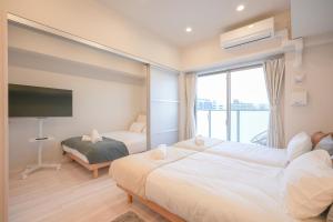 a hotel room with two beds and a large window at AYA Residence大阪城公園 Osaka Castle JR Morinomiya 徒歩5min in Osaka