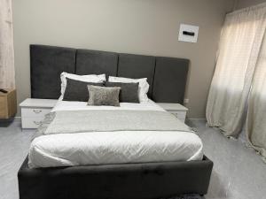 a large bed with a large headboard in a bedroom at BNG Suites 2 in Jwaneng