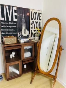 a mirror sitting next to a wooden stand with a table at 하우스 The 쉼 in Suwon