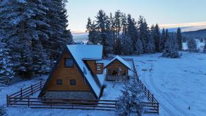 a log cabin in the snow with trees at Vikendica Monte Pino Romanija in Sokolac