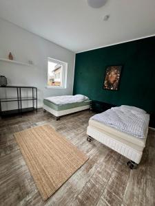 two beds in a room with a green wall at Apartment im Grünen in Kroppach