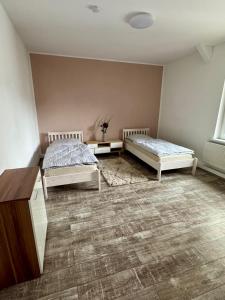 a room with two beds and a dresser in it at Apartment im Grünen in Kroppach +2 photos