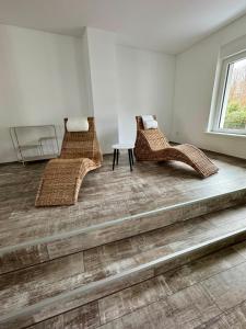 two wicker chairs and a table in a room at Apartment im Grünen in Kroppach