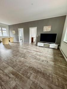 an empty living room with a flat screen tv and a large flat screen at Apartment im Grünen in Kroppach