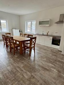 a kitchen with a wooden table and chairs in a room at Apartment im Grünen in Kroppach