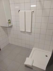 a white tiled bathroom with a tub and towels at Retiro das Camélias 3 in Lajes das Flores +22 photos