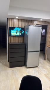 a kitchen with a refrigerator and a tv in it at Sol y Sal in Torrevieja