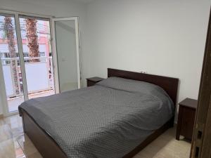 a bedroom with a bed and two windows at Sol y Sal in Torrevieja