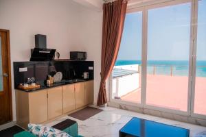 a living room with a large window with a view of the ocean at Trinco Beachfront Villas AJS in Trincomalee