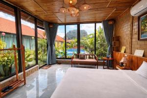 a bedroom with a bed and large windows at Trang An Green Retreat Homestay in Ninh Binh