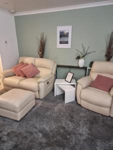 a living room with two couches and a couch at Plum Cottage in Keswick