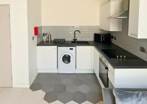 a kitchen with a washing machine and a sink at The Vault Liverpool City Centre sleeps 4 in Liverpool +39 photos