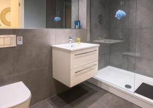 a bathroom with a white sink and a shower at The Vault Liverpool City Centre sleeps 4 in Liverpool