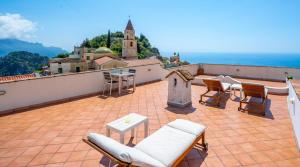 a patio with chairs and a table on a roof at La Casa Dei Venti in Amalfi