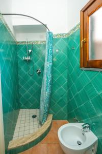 a green tiled bathroom with a shower and a sink at La Casa Dei Venti in Amalfi +42 photos