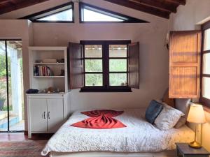 a bedroom with a bed with a red blanket on it at Studio in peaceful village of São Martinho das Amoreiras in São Martinho das Amoreiras
