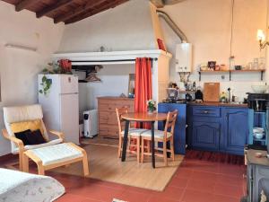 a kitchen with blue cabinets and a table and chairs at Studio in peaceful village of São Martinho das Amoreiras in São Martinho das Amoreiras