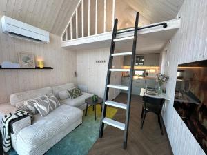 a living room with a couch and a loft bed at Greencabin - Cabin Escape in the Heart of Saaremaa in Pamma