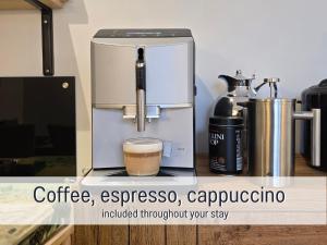 a coffee machine on a counter with a cup of coffee at Baham-Apartment Nuernberg - including hot tub, sauna, massage chair, roof terrace, barbecue - metro 15 min, exhibition center 8 min walk in Nuremberg