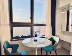 a room with a table and chairs and a window at Incheon Rest Stay in Taeam