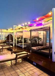 a building with tables and benches in front of the ocean at Incheon Rest Stay in Taeam