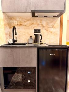 a kitchen with a microwave and a sink at The Residence Myrina in Myrina