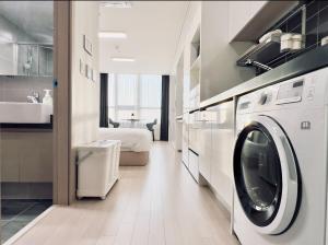 a bathroom with a washer and dryer in a room at Incheon Rest Stay in Taeam