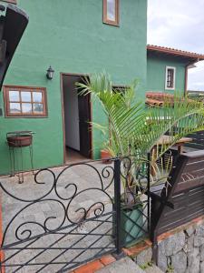 a green building with a gate and a house at Búzios Casa n# 3 in Búzios